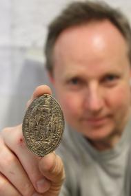 Ein verspätetes Weihnachtsgeschenk: Paderborner Stadtarchäologe Dr. Sven Spiong mit dem neueentdeckten Siegelstempel des Paderborner Benediktinerabtes Jodocus. <br>Foto: LWL/Museum in der Kaiserpfalz<br />