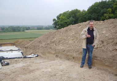 Dr. Christoph Grüneberg von der Außenstelle Münster der LWL-Archäologie erläutert die bisherigen Erkenntnisse über die Wallburg in Ahlen-Dolberg am Prospektionsschnitt. <br>Foto: LWL<br />