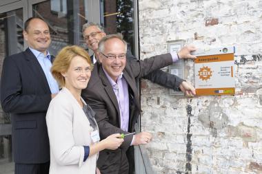 ERIH-Schatzmeister Andreas Kuchajda, Nadine Schober, Museumsleiter Dr. Hermann Josef Stenkamp und Dirk Zache, Direktor des LWL-Industriemuseums (v.l.) brachten am Donnerstag das ERIH-Schild am Eingang zur Spinnerei des TextilWerks Bocholt an. <br>Foto: LWL / A. Hudemann<br />