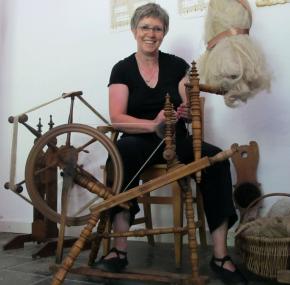 Die Fäden in der Hand: Handwebmeisterin Marita Schäfers führt in die Grundlagen der Garnverarbeitung am Spinnrad ein.<br> Foto: LWL/M.TIllmann<br />