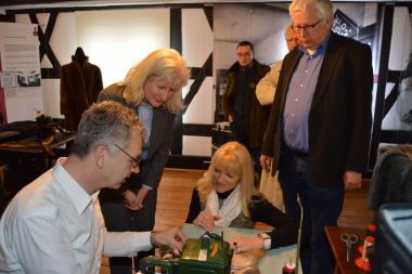 Jochen Schleuter (v.l.) von Pelzhaus Wolff in Hagen zeigt der stellvertretenden Museumsleiterin Dr. Anke Hufschmidt, LWL-Kulturdezernentin Dr. Barbara Rüschoff-Thale und LWL-Museumsleiter Dr. Uwe Beckmann, wie Pelze genäht werden. <br>Foto: LWL<br />