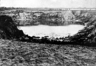 Der große Erdfall kurz nach dem Einbruch am 14.04.1913. Rechts im Hintergrund steht am Wasser ein Mensch als Größenvergleich. <br>Foto: Archiv LWL-Museum für Naturkunde.<br />