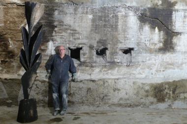 Karl Manfred Rennertz mit einer seiner Holzskulpturen im Untergeschoss der Gebläsehalle. <br>Foto: LWL / Hudemann