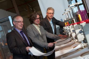Dirk Zache, Martin Schmidt und Dr. Hermann Josef Stenkamp (v.l.) an einer elektronischen Stickmaschine aus den 1980er Jahren. Sie ist funktionstüchtig und wird wie weitere Maschinen in der laufenden Spinnerei-Saison auch in Betrieb gezeigt. <br>Foto: LWL/Betz<br />