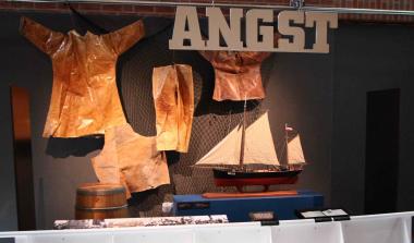 Das Schiffsmodell und das Ölzeug der Heringsfänger in der Ausstellung ¿Wanderarbeit¿. <br>Foto: LWL