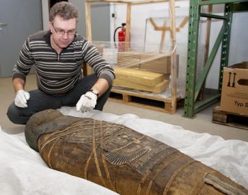 Ausstellungstechniker Sven Jüttemeier mit der Mumie im Sonderdepot des LWL-Industriemuseums. <br>Foto: LWL/Hudemann