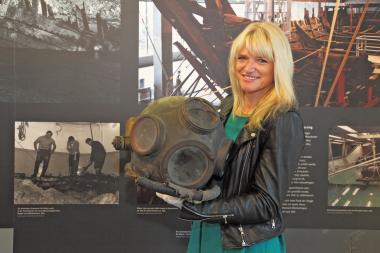 LWL-Kulturdezernentin Dr. Barbara Rüschoff-Thale mit einem Helm, den Taucher 1963 bei der Bergung der ¿Bremer Kogge¿ trugen. <br>Foto: LWL/Holtappels 