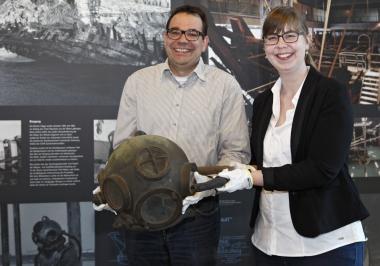 Dr. Arnulf Siebeneicker und Linda Wilken mit einem Helm, den Taucher 1963 bei der Bergung der ¿Bremer Kogge¿ trugen. <br>Foto: LWL/Holtappels 