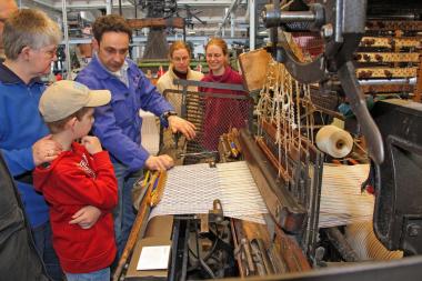 Bei der Familienführung erfahren die Teilnehmer am laufenden Webstuhl, wie ein Stoff entsteht. <br>Foto: LWL/Holtappels 