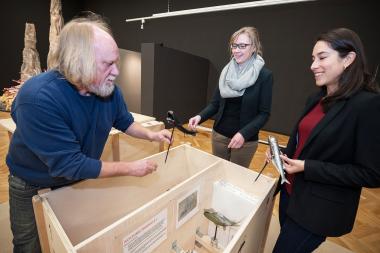 Zoologischer Chefpräparator Werner Beckmann (li.) öffnet mit den Ausstellungsmacherinnen, Dr. Katharina Freyth-Weber (M.) und Andrea Florez Jurado, eine der Kisten mit den Leihgaben aus der Schweiz. <br>Foto: LWL/Steinweg 