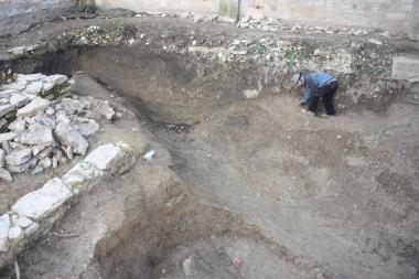 Vor 1.000 Jahren verfüllter Hofgraben. Grabungsmitarbeiter Dennis Hübel entfernt die letzten Erdbrocken aus der zwei Meter tiefen Anlage. <br>Foto: LWL/Spiong