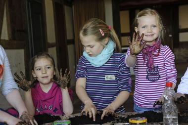Zeigt her eure Hände: Beim Herstellen der Saatgut-Bälle im LWL-Freilichtmuseum Detmold darf in der Erde gewühlt werden. <br>Foto: LWL