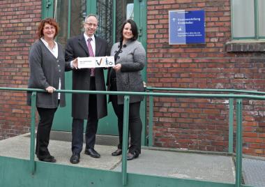 Anja Hoffmann, LWL-Direktor Matthias Löb und Dr. Anne Kugler-Mühlhofer (v.l.) mit dem Zertifikat ¿Barrierefreiheit geprüft¿ am Eingang zur Lampenstube.<br> Foto: LWL/Marx