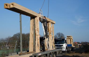 Die fertig montierten, teilweise mehr als acht Meter langen Einzelteile für die Rekonstruktion von Westtor und Holz-Erde-Mauer werden angeliefert. <br>Foto: LWL/Burgemeister