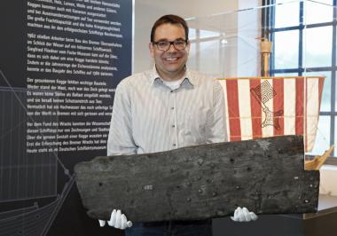 Dr. Arnulf Siebeneicker mit einer originalen Planke der ¿Bremer Kogge¿ aus dem 14. Jahrhundert.<br>Foto: LWL/Holtappels