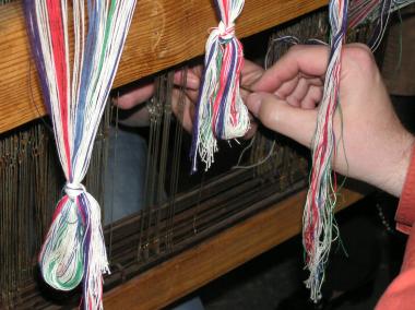 Zur Vorbereitung der Webkette werden Fäden eingezogen. <br>Foto: LWL 