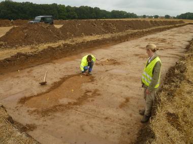 Unter der Fachaufsicht der LWL-Archäologie für Westfalen untersuchen die Archäologen den freigelegten Boden auf der Fläche des geplanten Gewerbegebietes "Schürenfeld" in Fröndenberg.<br>Foto: LWL/Baales