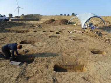 Am Südrand des Dorfes sind sechs Pfostenlöcher einer Heuberge kreisförmig angelegt. Im Hintergrund ist die Reihe der doppelten Pfostenlöcher des Dorfzaunes zu sehen.<br>Foto: LWL/S. Spiong