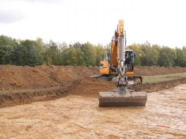 Der Bagger bereitet die Fläche für die archäologischen Untersuchungen im Gewerbegebiet in Meschede Enste vor.<br>Foto: LWL/Baales