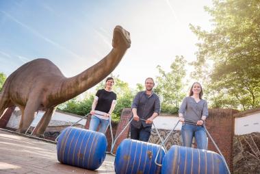 Wie man einen Hippo Roller nutzt, führen die Ausstellungsmacherinnen Vanessa Rüttler (li.) und Jana Johe (re.) gemeinsam mit dem wissenschaftlichen Kurator Dr. Jan Ole Kriegs vor.<br>Foto: LWL/Steinweg
