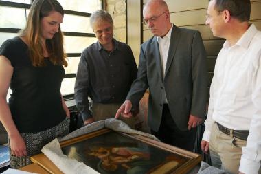 v.l.n.r) Volontärin Katharina Wochnik, Museumsleiter Dr. Martin Kroker, Historiker Wilhelm Krüggeler und Pfarrer Dr. Ekhard Düker begutachten das Bild, das aus dem Abdinghof stammt und jetzt als Leihgabe zurück nach Paderborn kommt - in die Sonderausstellung über das Kloster.<brFoto: LWL/K. Burgemeister