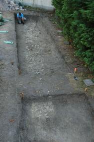 Grabungsmitarbeiter Sven Schelhammer legt das erste Hausfundament in nur 30 cm Tiefe frei.<br>Foto: LWL/Eggert