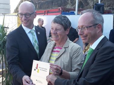 (v.l.) Bürgermeister Bernd Hedtmann, Dr. Barbara Hendricks und Matthias Löb bei der Übergabe der Plakette Nationale Projekte des Städtebaus.<br>Foto: BMUB/Kübler