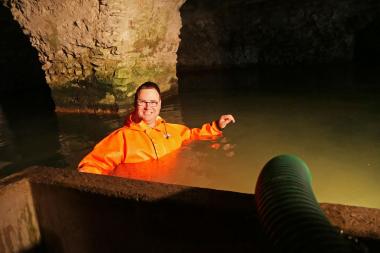 Bis zur Brust mussten die Mitarbeiter des Stadtentwässerungsbetriebes ins elf Grad kalte Quellwasser, um die Schläuche und Pumpen zu installieren. <br>Foto: LWL/Burgemeister 