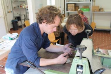 Der Kunstpädagoge und Graphiker Hannes Schützler an der Druckpresse in der Glashütte Gernheim.<br>Foto: LWL