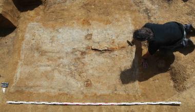 Bei seiner Entdeckung präsentierte sich das Grab noch recht unscheinbar. Zwei der drei Schildbuckel sind als runde braune Verfärbungen aber schon deutlich erkennbar<br>Foto: LWL/Cichy