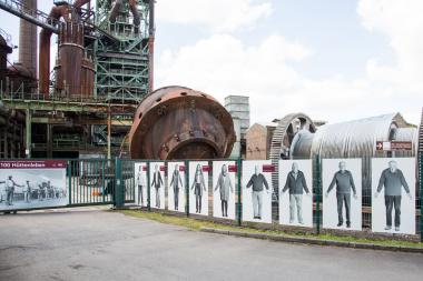 Am Museumszaun vor dem Hochofen bilden 100 lebensgroße Bilder eine fotografischen Menschenkette.<br>Foto: LWL / Harms