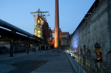 Im Schatten des beleuchteten Hochofens erkunden die Teilnehmer die Industriebrache.<br>Foto: LWL/Hudemann