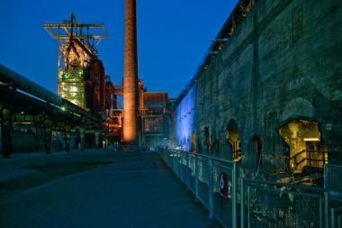 Im Schatten des beleuchteten Hochofens erkunden die Teilnehmer die Industriebrache.<br>Foto: LWL/Hudemann