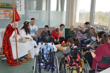 Hassan (4. v. links) freut sich inmitten seiner Regenbogen-Schulklasse über den adventlichen Besuch vom Nikolaus und Engelchen. <br>FOTO: LWL/ Märk