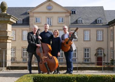 Bestens gestimmt: Carsten Hormes, künstlerischer Leiter des KulturBüro-OWL, Daniel Saage von der WestfalenWIND Strom GmbH, Veranstaltungskoordinatorin Alexandra Buterus und Museumsdirektor Dr. Ingo Grabowsky vom LWL-Landesmuseum für Klosterkultur (v.l.) freuen sich auf die "Sommernachtslieder" in der einmaligen Atmosphäre des Ehrenhofs im Kloster Dalheim.<br>Foto: LWL/Johanna Pietsch