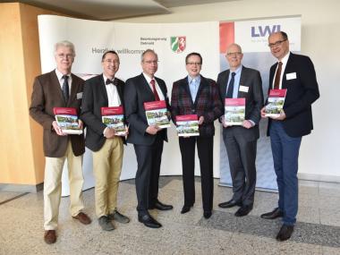 LWL-Direktor Matthias Löb (3.v.l.) übergibt den kulturlandschaftlichen Fachbeitrag zur Regionalplanung für den Regierungsbezirk Detmold an Regierungspräsidentin Marianne Thomann-Stahl (3.v.r.). Mit Ihnen freuen sich Projektleiter Horst Gerbaulet, LWL-Chefarchäologe Prof. Dr. Michael Rind, Christian Rösgen vom NRW-Wirtschaftsministerium und LWL-Chefdenkmalpfleger Dr. Holger Mertens.<br>Foto: LWL/Bodi