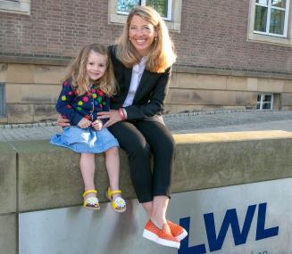Als Führungskraft in Teilzeit kann Eva Beermann - hier mit ihrer jüngsten Tochter Carla vorm LWL-Landeshaus - Beruf und Familie vereinbaren.<br>Foto: LWL/Köhler