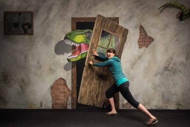 Alle Museumsgäste können genau wie Ausstellungsmacherin Dr. Julia Massier einmal selbst probieren dem Dino der Illusionsmalerei den Weg zu versperren.<br>Foto: LWL/Steinweg
