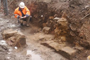 Grabungsleiter Thies Evers legt eine Detailzeichnung der Mauerreste an, bevor sie vom Fundament für den Neubau überdeckt werden. Foto: EggensteinExca