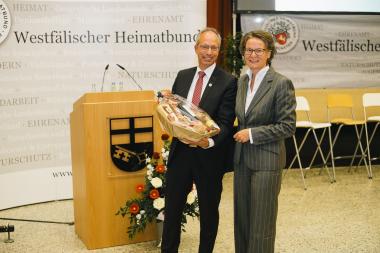LWL-Direktor und WHB-Vorsitzender Matthias Löb überreicht NRW-Heimatministerin Ina Scharrenbach einen Geschenkkorb mit westfälischen Spezialitäten.<br> Foto/ WHB/ Hubertus Huvermann