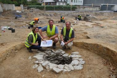 Hinter einem mittelalterlichen Brunnen: Dr. Sveva Gai und Till Lodemann von der Stadtarchäologie Paderborn sowie Grabungsleiter Dr. Dieter Lammers.<br>Foto: LWL/N. Wolpert