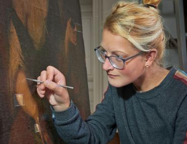 LWL-Restauratorin Stephanie Keinert bei der Unter-suchung eines Gemäldes.<br>Foto: LWL/Dülberg