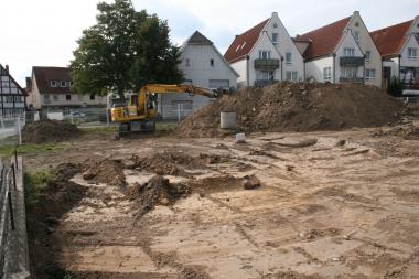 Während des Oberbodenabtrags im August zieht ein Bagger im Bereich des Baufeldes die obersten Erdschichten ab - darunter kamen die ersten archäologischen Befunde zum Vorschein, die nun näher untersucht werden.<br>Foto: B. Grundmann/LWL-AfW