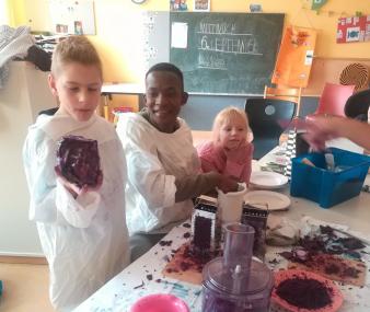 Thabo Mpholo aus Südafrika leitet Kinder der LWL-Förderschule am Marsbruch in einem Workshop an: Wie lässt sich aus Rotkohl Farbe gewinnen?<br>Foto: Hierl/LWL-Förderschule am Marsbruch