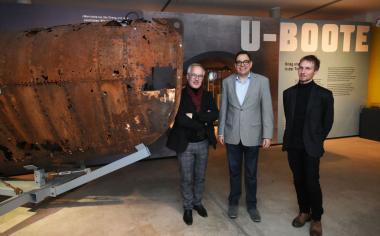 Dirk Zache, Dr. Arnulf Siebeneicker und Michael Grünwald (v.l.) vor dem verrosteten Bug eines Klein-U-Boots vom Typ Seehund.<br>Foto: LWL/Appelhans