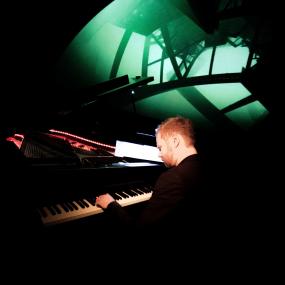 Kai Schuhmacher spielt seine Klaviermusik begleitet von Fulldome-Visualisierungen an der Planetariumskuppel.<br>Foto: Marvin Boehm