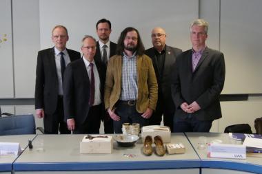 Auf der Pressekonferenz stellte LWL-Archäologe Dr. Manuel Zeiler (3.v.r.) einige der Funde vor, die vom Alltag der Zwangsarbeiter zeugen. Hinter den Funden stehen die Redner des Tages: (v.l.) Bürgermeister von Meschede Christoph Weber, LWL-Direktor Matthias Löb, Russlandbeauftragter der Bundesregierung Dirk Wiese, LWL-Archäologe Dr. Manuel Zeiler, Bürgermeister der Stadt Warstein Dr. Thomas Schöne und LWL-Historiker Dr. Marcus Weidner.<br>Foto: LWL/Nils Wolpert