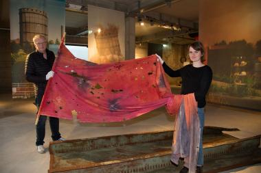 Museumsleiter Robert Laube und Kuratorin Delia Pätzold mit einem Transparent des Hattinger Künstlers Egon Stratmann aus der Zeit des Hüttenkampfes.<br>Foto: LWL / Hudemann