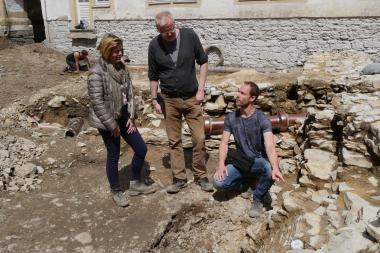 Im Innenhof des Theodorianums diskutiert (v.l.n.r.) Stadtarchäologin Sveva Gai (LWL-Archäologie für Westfalen) zusammen mit den beiden Grabungsleitern Robert Gündchen und Robert Süße (beide EggensteinExca) einen nachträglich in die mittelalterliche Mauer eingelassenen Lichtschacht.<br>Foto: LWL/J. Schubert