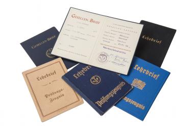 Noch immer ist der Gesellenbrief ein wichtiges Dokument: Auswahl von Gesellenbriefen aus den vergangenen Jahrzehnten.<br>Foto: LWL-Freilichtmuseum Hagen, Heike Wippermann